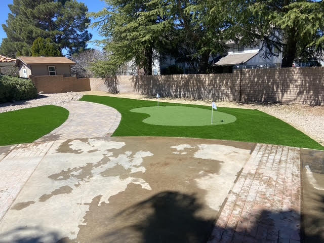 Backyard putting green and artificial turf next to a paver driveway in Lake Havasu City